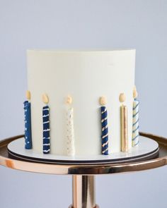 a white cake with blue and gold candles on it