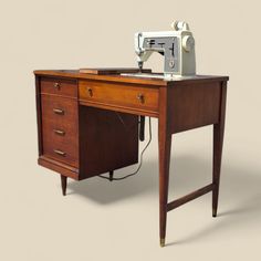 an old sewing machine sitting on top of a wooden desk