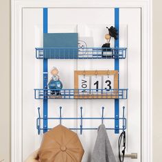 a blue metal shelf with books and other items on it next to a white door