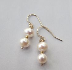 This listing is for a pair of beautiful classic creamy white pearl earrings on either 14k gold filled French ear wires or solid 14k gold French ear wires. These are a minimalist pair of stellar cultured pearls stacked between 14k beads. Pearls - 8mm The finish is either 14k solid gold ear wires or 14k gold filled wires, both French style as pictured above. Length of earrings from top of ear wire - 3/4 inch Arrives beautifully gift wrapped 14k Gold Filled Pearl Drop Earrings For Anniversary, Elegant White 14k Gold Filled Bridal Earrings, White 14k Gold-filled Drop Pearl Earrings, Classic Pearl Bridal Earrings With Ear Wire, White 14k Gold Filled Earrings For Weddings, White 14k Gold Filled Bridal Earrings For Wedding, Classic Pearl Earrings With Ear Wire For Weddings, Classic Pearl Drop Earrings In 14k Gold Filled, Wedding Pearl Earrings With 14k Gold Filled Ear Wire