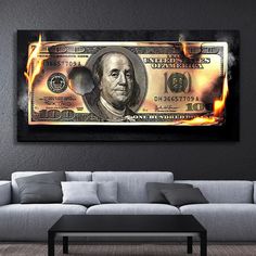 a living room with a couch, coffee table and fire burning money on the wall