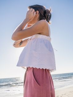 The Rita top updated in a crisp white eyelet fabric rescued from a dead stock warehouse. Pretty scallop edging and delicate embroidery give this classic white tank a vintage feel. Adjustable ties and roomy elastic fit accommodates a multitude of sizes. 100% cotton deadstock One Size Top elastic relaxed flat 11", stretches to 20" Bottom opening flat 22.5" Body length from shoulder is 19" Falls at waist for a slightly cropped fit Fully lined Hand wash cold, line dry Consciously made in small batch Sleeveless Cotton Eyelet Top, Summer Tops With Scalloped Edges For Daywear, Summer Cotton Tops With Scalloped Edges, Summer Top With Scalloped Edges For Day Out, Sleeveless Scalloped Edges Tank Top For Summer, Summer Sleeveless Tank Top With Scalloped Edges, White Sleeveless Eyelet Top, White Sleeveless Top With Eyelet Details, White Scalloped Edges Tops For Summer