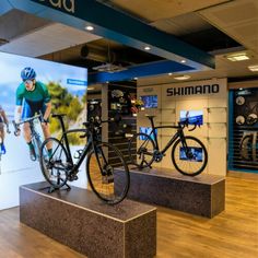 two bikes are on display in a bike shop with an ad for shimano