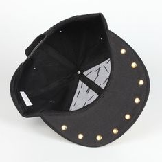 a black hat with gold studs on the side and a baseball cap in the middle