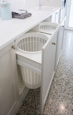 a laundry basket is in the middle of an open cabinet