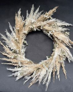 a dried wreath with white flowers on it