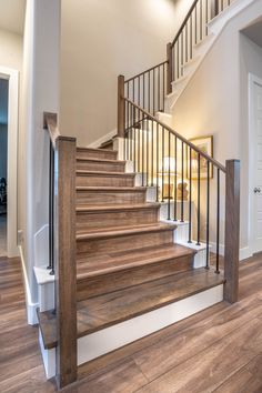 a staircase with wooden handrails and white walls