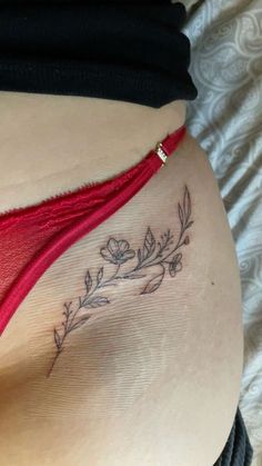 a woman's stomach with a tattoo on her belly and flowers in the bottom