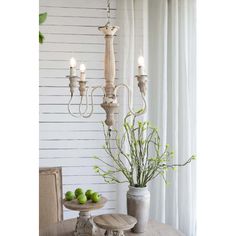 a chandelier hanging from the ceiling next to a table with fruit on it