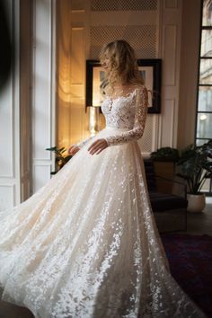 a woman in a wedding dress is standing near a door and looking at the window