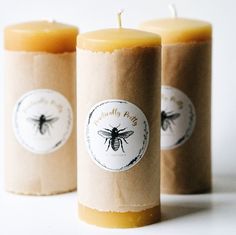 three bees waxed candles sitting next to each other