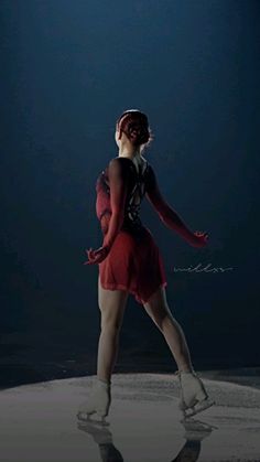 a woman is skating on an ice rink in the dark with her hands behind her back