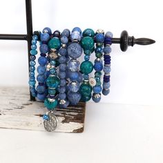 Beaded blue bracelets. Indulge in the unique charm of these handmade Stackable Bracelets, designed to add a touch of boho chic to your style. Crafted with an array of materials. These bracelets are versatile enough for solo wear or for stacking with others. The color palette of denim blue, light blue, dark blue, and green will complement various outfits.  Sold individually.  Designed and handmade by me.  Comfortable fit for wrists ranging from 6.50" to 7.50", these bracelets are strung with professional stretch cord.  Delivered in a gift box or bag, they make for a perfect present or a stylish treat for yourself. Available per bracelet or mix and match.  1.    Stretch, Blue Coral, African silver, Lapis Lazuli 2.   Stretch, faceted Mystic Agate, Apatite 3.   Includes Sterling Silver lobster Turquoise Wrap Bracelet Gift, Turquoise Wrap Bracelet Great For Gifts, Handmade Blue Bohemian Stretch Bracelet, Blue Bohemian Handmade Stretch Bracelet, Adjustable Blue Stackable Wrap Bracelet, Blue Bohemian Handmade Wrap Bracelet, Blue Stackable Bracelets For Gift, Blue Stackable Bracelets As Gift, Blue Stackable Wrap Bracelet As Gift