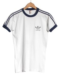 Vintage 1970's Adidas t shirt in a white colour. Trefoil on the chest and trademark three stripes down the sleeves. Made from a cotton polyester blend.  Condition: Excellent vintage condition. Bust: 34in Length: 25in More vintage clothing on our website www.brickvintage.com Affordable Trendy Adidas T-shirt, Vintage Adidas Shirt, Classic White Tops With Three Stripes, Classic White Top With Three Stripes, Retro White Top With Three Stripes, White Retro Top With Three Stripes, Retro Three Stripes T-shirt For Streetwear, Retro Cotton T-shirt With Three Stripes, Vintage White Crew Neck T-shirt