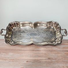 an ornate silver tray on a wooden table