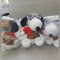 three stuffed dogs are sitting on a couch with plastic wrap around them and one dog is wearing goggles