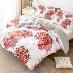 a bed with red and white coral print on it