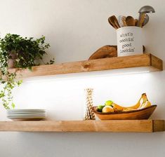 two wooden shelves with bowls, plates and utensils on them