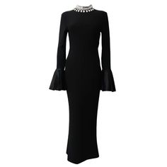 a black dress with bell sleeves and an embellishment on the neckline is shown