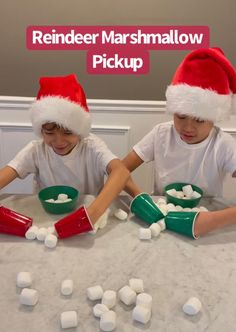 two children in santa hats making marshmallows at a table with the words reindeer marshmallow pick up