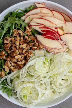 an apple and walnut salad in a bowl with lettuce, celery