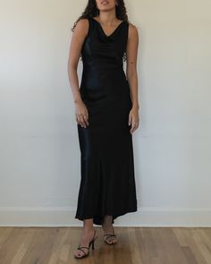 "Black cowl neck bias cut evening dress c. 1990s. Double-layered viscose blend satin. Sleeveless construction with cowl neckline. Fitted throughout bodice with slightly more relaxed fit from hips down. V cut back with subtle train. Invisible zipper at back center. tag size: 4 modern size estimate: small composition: 54% viscose 46% acetate (100% acetate lining) label: ABS Evening by Allen Schwartz made in USA condition: excellent MEASUREMENTS bust - 32\" waist - 27\" hips - 35\" length (front) - 59\" length (back) - 61\" shown unpinned on a 5'9\", size small model please review our shop policies prior to purchase" Luxury Satin Dress With Bias Cut And Asymmetrical Neckline, Luxury Sleeveless Bias Cut Silk Dress, Luxury Slip Dress With Ruched Bodice And Sweetheart Neckline, Luxury Chic Slip Dress With Cowl Neck, Vintage Black Silky Maxi Dress, Luxury Bias Cut Midi Dress With Straight Neckline, Luxury Asymmetrical Bias Cut Satin Dress, Elegant Cheap Scoop Neck Dress, Luxury Bias-cut Dress With Cowl Neck