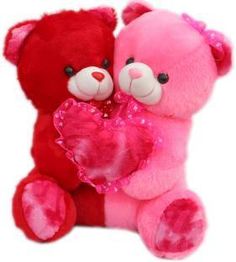 two teddy bears sitting next to each other holding a heart shaped object in their hands