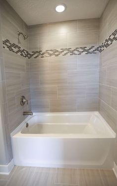 a white bath tub sitting inside of a bathroom next to a shower head and faucet