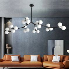 a living room filled with lots of furniture and lights hanging from it's ceiling