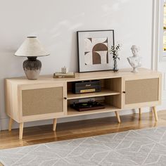 a living room with a tv stand, lamp and pictures on the wall above it