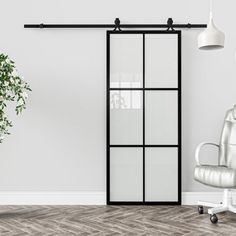 an office chair sitting in front of a white wall with glass panels on the doors