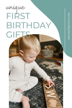 a young child playing with a wooden name puzzle on the floor in front of a blue and white background