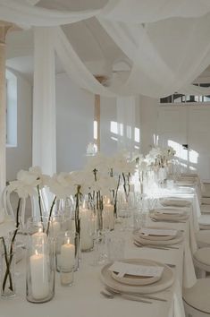 a long table is set with white flowers and candles