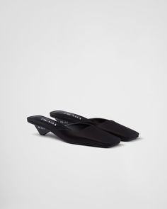 Black Satin Mules | PRADA Modern Low Heel Mules With Branded Heel Counter, Elegant Sandals With Reinforced Flat Heel, Evening Mules With Leather Sole And Low Heel, Classic Mules With Contrasting Heel Counter, Formal Mules With Contrasting Low Heel, Formal Flat Heel Mules With Padded Heel, Designer Heels With Removable Insole For Work, Black Pointed Toe Business Sandals, Classic Pointed Toe Sandals With Reinforced Heel