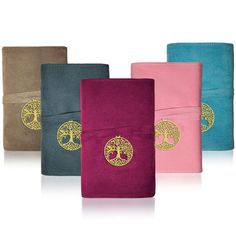 four different colored notebooks with gold tree on them