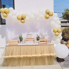 the table is set up outside with balloons and decorations on it for an elegant celebration