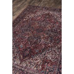 an antique persian rug with red and blue colors on a wooden floor in the middle of a room