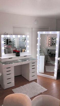 a white vanity with lighted mirrors and stool