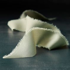 two pieces of white fabric sitting on top of a table