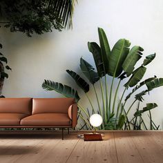 a couch sitting in front of a wall with plants on it