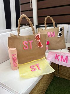 two personalized beach bags sitting next to each other on a table with sunglasses and sunscreen