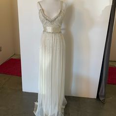 a dress on display in front of a white wall and red carpeted flooring