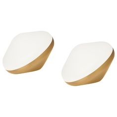 two white and gold plates sitting next to each other on a white surface with no one in it