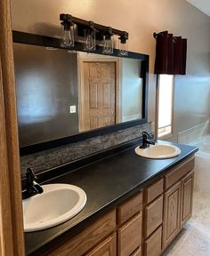 a bathroom with double sinks and mirrors in it