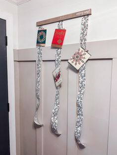 three books are hanging on the wall in front of a door with ribbons attached to it