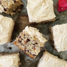 several pieces of cake sitting on top of a wooden cutting board next to a red flower