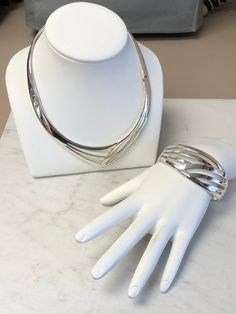 "A Beautiful Classic Sterling Silver Large Solid Bracelet and Necklace Set. The Bracelet is very solid and well-made with two hinges and a hidden clasp. The inside opening dimension is 2 1/4\". The wide is 1 1/8\" and graduated down to 5/8\" in the back. The Necklace is also solid and well-made with double hinges to open with a hidden clasp. This choker would fit for a 16\" neckline. Both of these open design pattern has a bright shiny plain polish finish. This is only sold as a set. This item w Flexible Silver Cuff Bracelet For Formal Occasions, Formal Flexible Silver Cuff Bracelet, Sterling Silver Bracelet With Shiny Finish For Formal Occasions, Silver Jewelry With Oyster Bracelet For Evening, Silver Oyster Bracelet Jewelry For Evening, Unique Oyster Bracelet For Formal Occasions, Formal White Gold Jewelry With Box Clasp, Luxury Hinged Jewelry For Gifts, Elegant Silver Cuff Bracelet With Box Clasp