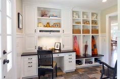 a room that has some white cabinets and black chairs in it with brown tile flooring