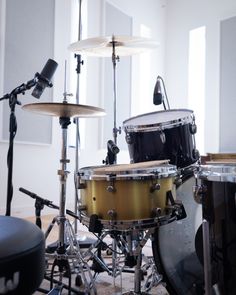 a drum set up in front of a microphone and some other musical equipment on the floor