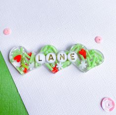 This is a cute Grinch inspired hair clip with clay hearts white snow flakes and bright green sprinkles.  At Checkout: - Pick Shape of your clip - Select letter bead colors you would like - Let me know what personalization you want (name or phrase) up to 9 letters per row or choose a wider clip for multiple rows - If you have a preference for the side of the head also let me know, right side will be the default. Details: - Clips are approximately 2.5 in long, ask me for specifics if you are curious about a specific shape. - This listing is for a SINGLE clip - Alligator clips are attached to the back and will be silver (occasionally gold and gold upon request). - Clips are made from resin and can be heat sensitive - Each clip is handmade and may vary from photos slightly and have slight impe Cute Grinch, Clay Hearts, Christmas Clay, Snow Flakes, White Snow, Alligator Clips, Shape Of You, Letter Beads, Barrette Clip